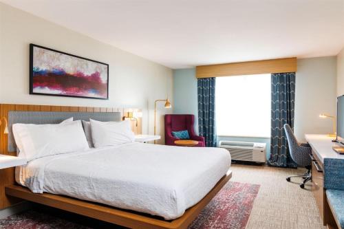 a hotel room with a bed and a desk at Hilton Garden Inn New York/Staten Island in Staten Island