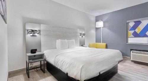 a hotel room with a large bed and a yellow chair at Quality Inn Prattville I-65 in Prattville
