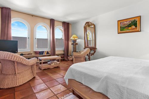 Un dormitorio con una cama, un escritorio y un televisor. en Maison Ferienhaus Grillons, en Saint-Tropez