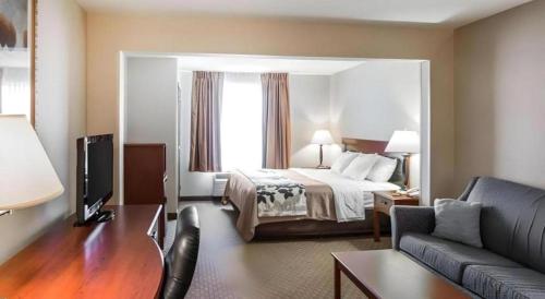 a hotel room with a bed and a couch at Rodeway Inn & Suites Salina South in Salina
