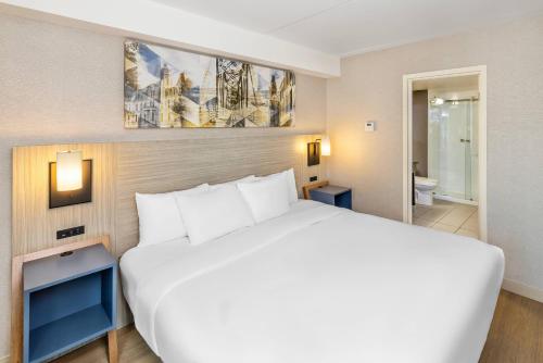 a bedroom with a large white bed and a bathroom at Comfort Inn in Fredericton