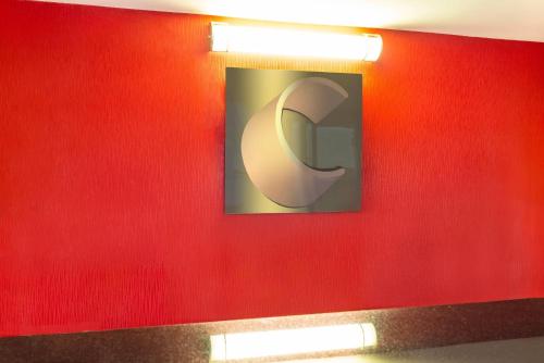 a red wall with a picture of a c on it at Comfort Inn in New Glasgow
