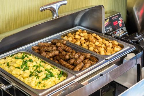 a buffet with several trays of meat and vegetables at Comfort Inn in New Glasgow