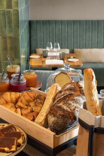 een tafel met verschillende soorten brood en gebak bij Hotel de la Plage in Erquy