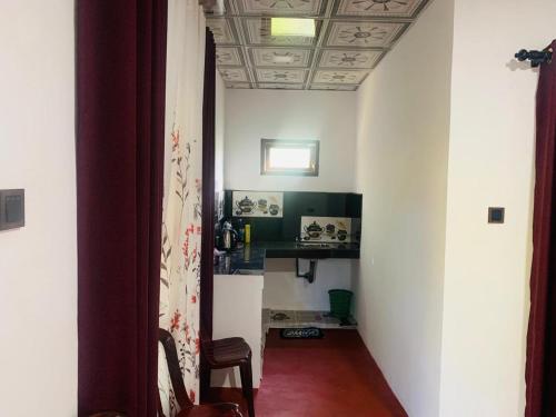 a hallway with a table and a chair in a room at Secret Pearl Ella in Bandarawela
