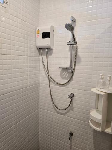 a shower in a white tiled bathroom at Baan Khun Pra Chiang Mai Near Chiang mai Airport in Chiang Mai
