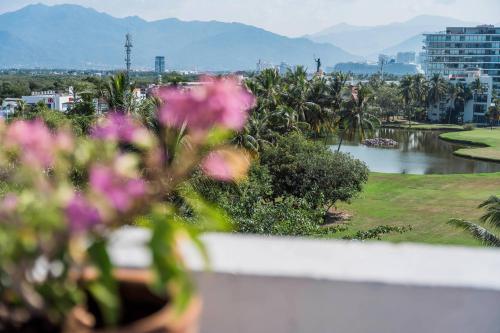 a view of a river from a balcony with flowers at Comfort Inn Puerto Vallarta Golfside & Marina in Puerto Vallarta
