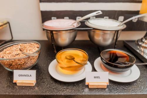 a counter with bowls of coffee and bowls of food at Comfort Inn Puerto Vallarta Golfside & Marina in Puerto Vallarta