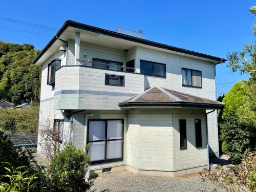 a white house with a balcony on top of it at いちほの宿 友秀 in Makinohara