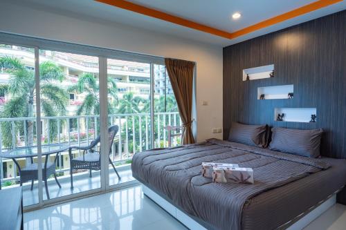 a bedroom with a large bed and a balcony at New Nordic Suites 2 by Apartwell in Pattaya South