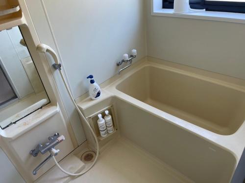 a bathroom with a tub and a sink at いちほの宿 友秀 in Makinohara