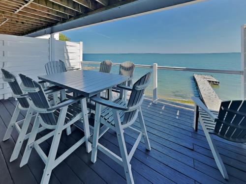 a table and chairs on a deck with the ocean at Put-in-Bay Waterfront Condo #206 in Put-in-Bay