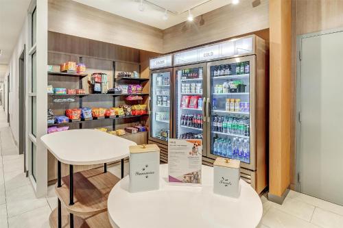 a store with two tables and a refrigerator with drinks at Home2 Suites By Hilton Crestview I-10 in Crestview
