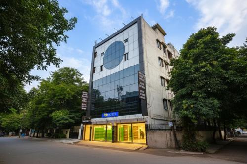 a tall white building with windows on a street at FabHotel Mona Continental - Nr Laxmi Nagar IT Hub in New Delhi