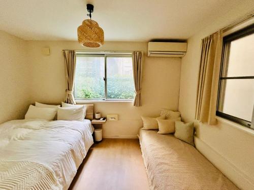 a small bedroom with two beds and a window at 晴Hare Hotel in Tokyo