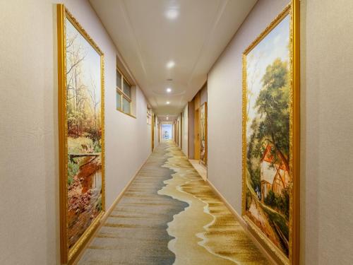 a hallway with paintings on the walls at Vienna Hotel Guangzhou Baiyun International Airport Branch in Guangzhou