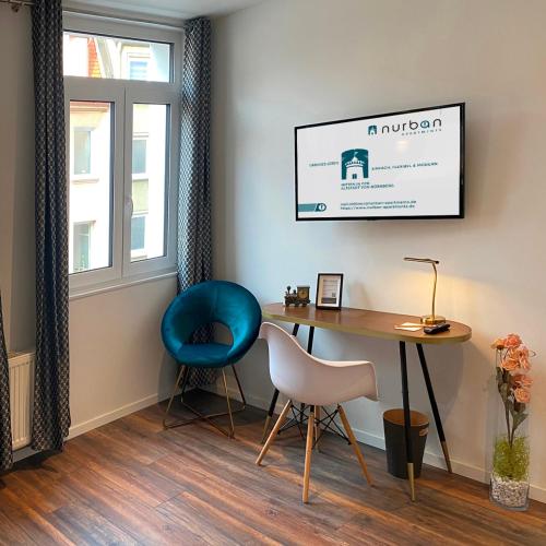 a living room with a desk and a blue chair at Nurban Apartments Oldtown in Nürnberg
