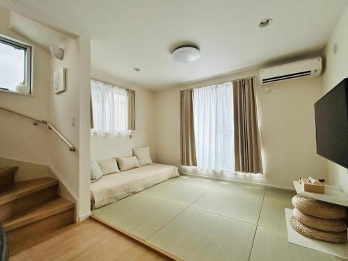 東京にある晴Hare Hotelのソファと窓のあるリビングルーム
