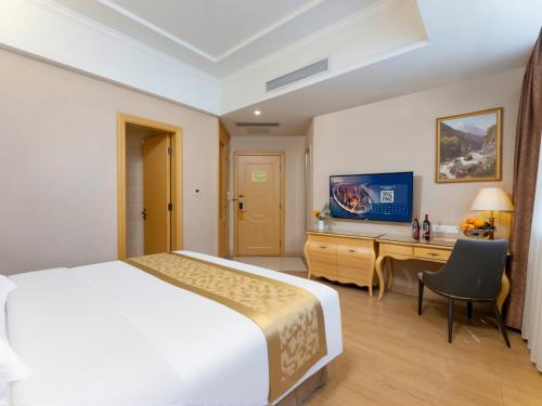 a hotel room with a bed and a desk at Vienna Hotel Guangzhou Baiyun International Airport Branch in Guangzhou