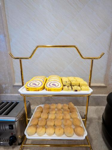 a tray of pastries on a table with a shelf at Vienna Hotel Guangzhou Baiyun International Airport Branch in Guangzhou