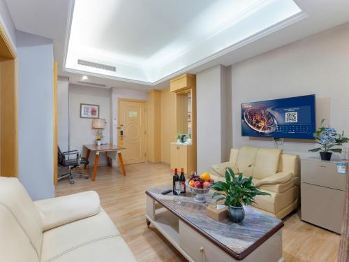 a living room with a couch and a table at Vienna Hotel Guangzhou Baiyun International Airport Branch in Guangzhou