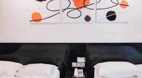 a bedroom with two beds with orange and black paint at Noble Park Hotel in Hong Kong