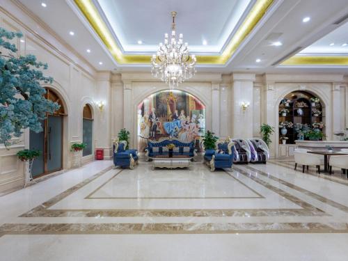 a large lobby with a chandelier and blue chairs at Vienna Hotel Guangzhou Baiyun International Airport Branch in Guangzhou