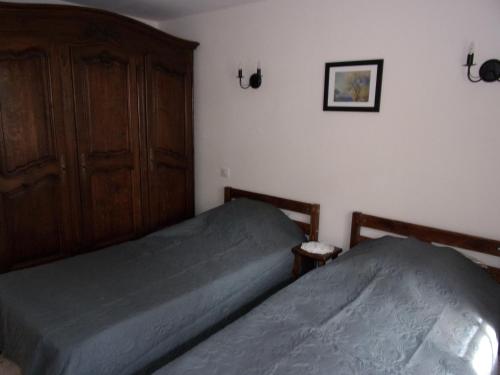 um quarto com 2 camas individuais e um armário em Appartement L'oranger em Pégomas