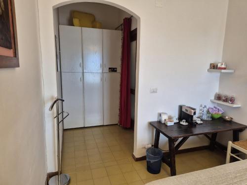 a hallway with a table and a refrigerator in a room at La terrazza di Anna in Sassari