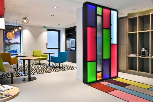 a colorful lobby with tables and chairs at Mercure Paris Gare de l'Est in Paris