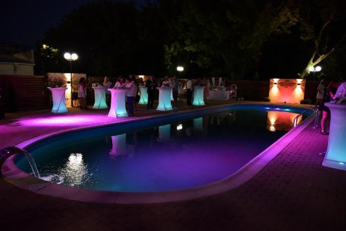 a swimming pool at night with purple lights at Bacolux Craiovita, Craiova in Craiova