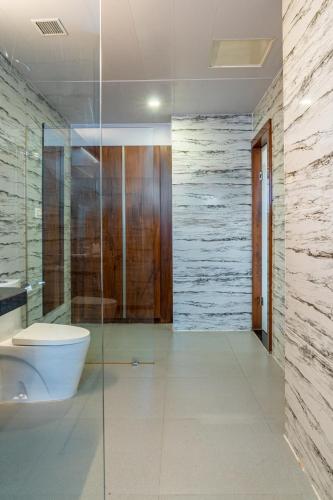 a bathroom with a toilet and a glass shower at Hotel Paandora Grand,Udaipur in Udaipur
