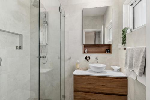 a bathroom with a sink and a glass shower at Stanwell Park Escape - Sprawling Beachfront Living in Stanwell Park