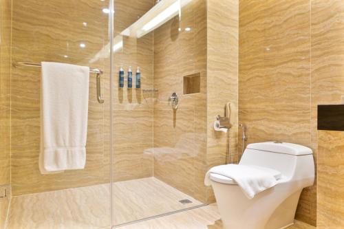 a bathroom with a toilet and a glass shower at Four Points by Sheraton Medan in Medan