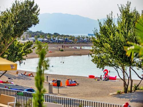 people on a beach with a body of water at Mobile Home in Omisalj by Pusca Bay Beach in Omišalj