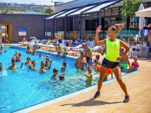 a woman running in front of a swimming pool at Mobile Home in Omisalj by Pusca Bay Beach in Omišalj