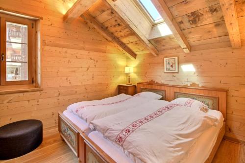 a bedroom with a bed in a log cabin at Chalet Eden, 4 Story Family Chalet in Champéry