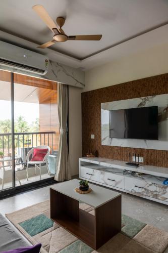 a living room with a flat screen tv on a wall at 1bhk with Pool & Wifi near Candolim beach in Nerul