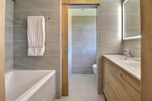 a bathroom with a tub and a sink and a toilet at Chalet Eden, 4 Story Family Chalet in Champéry