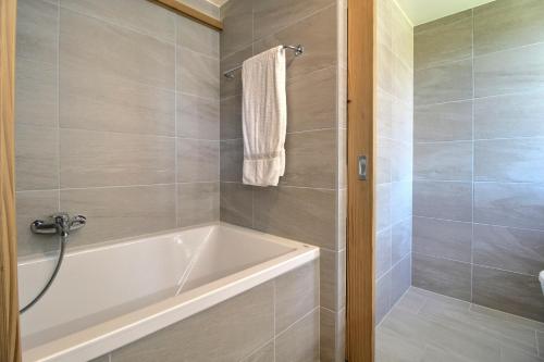 a bathroom with a white tub and a shower at Chalet Eden, 4 Story Family Chalet in Champéry