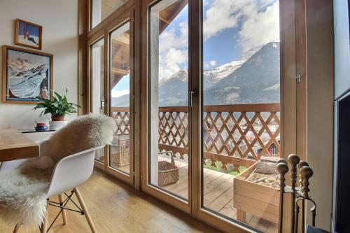 a room with a balcony with a view of a mountain at Chalet Eden, 4 Story Family Chalet in Champéry