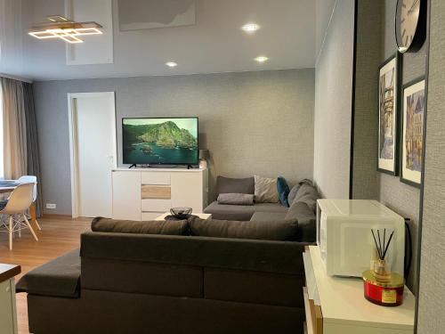 a living room with a couch and a flat screen tv at Like a home Linda Apartment in Narva