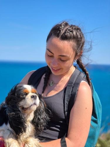 a woman holding a small dog on the beach at Mobil Home Luxe 3 chambres climatisé Canet en Roussillon in Canet-en-Roussillon