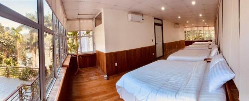 a bedroom with two beds and a balcony at Sunny Camping Sóc Sơn in Sóc Sơn