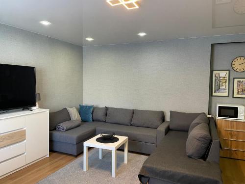 a living room with a couch and a flat screen tv at Like a home Linda Apartment in Narva