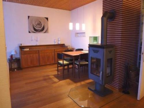 ein Wohnzimmer mit einem TV und einem Tisch mit Stühlen in der Unterkunft Ferienhaus Alpenblick Altenschwand in Altenschwand