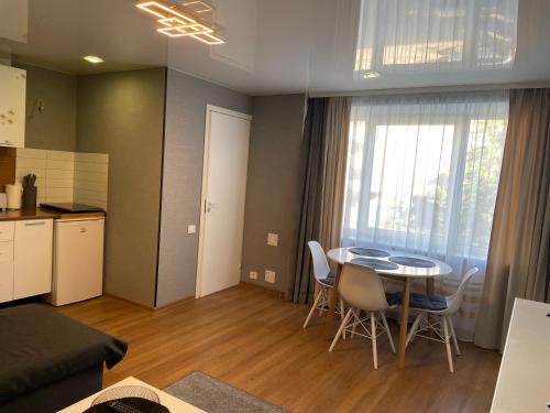 a kitchen and a living room with a table and chairs at Like a home Linda Apartment in Narva
