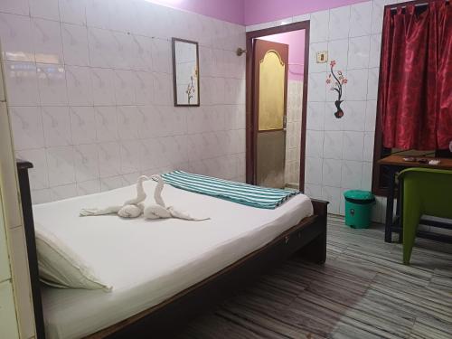a bedroom with a bed with two dolls on it at AGH Residency Triplicane in Chennai