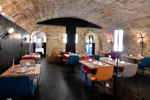 un restaurant avec des tables et des chaises et un mur de briques dans l'établissement Mercure Paris Gare de l'Est, à Paris