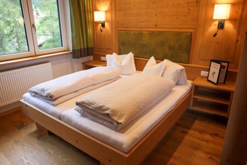 a large bed in a room with two pillows at Pension Muggengrat in Lech am Arlberg